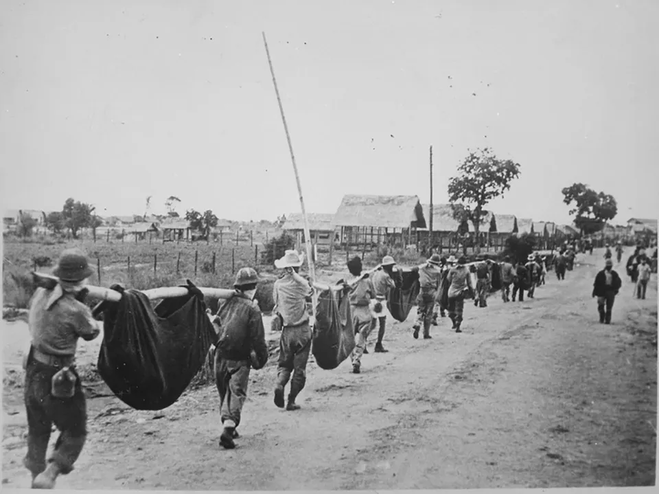 American prisoners of war carry their comrades during the Bataan Death March